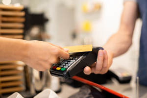 Client payant par carte bleue sur un TPE sans contact tendu par le commerçant